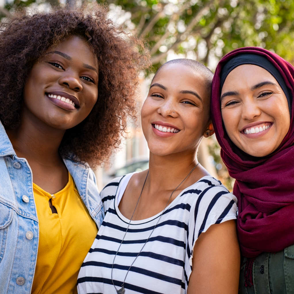 Three multi-cultural ladies smiling